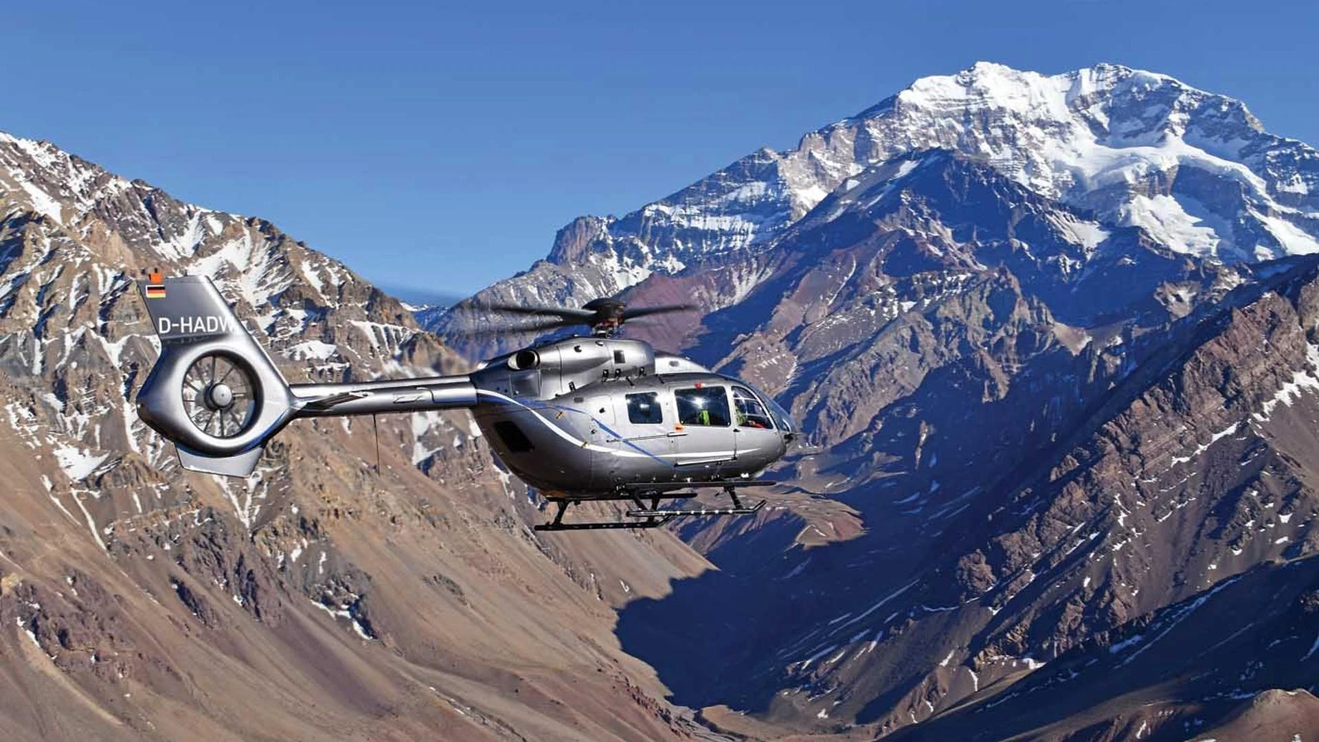 A helicopter crossing a mountain landscape