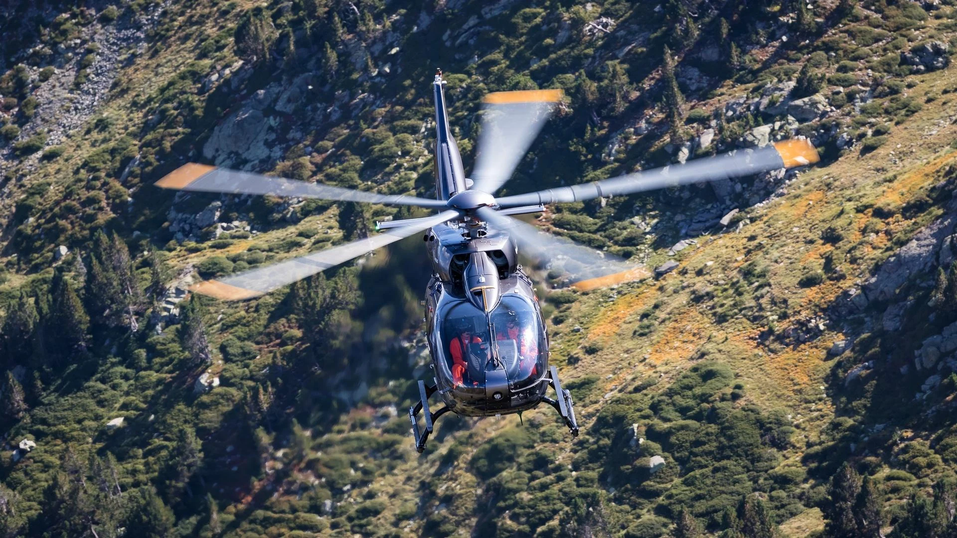 A helicopter operating above rugged terrain