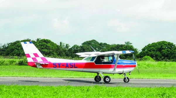 A training aircraft beside a green airfield